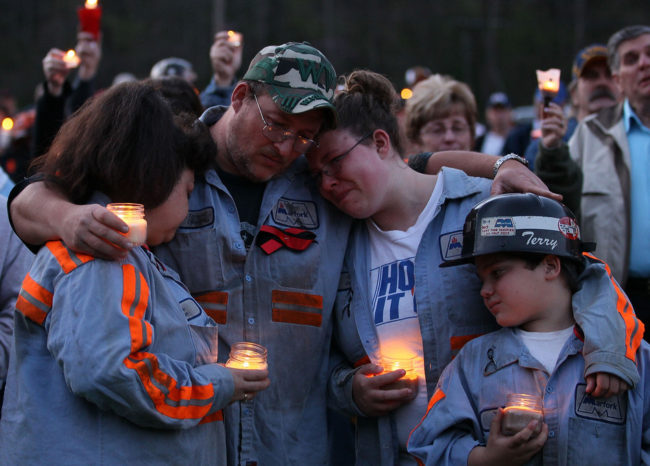 In this 2010 photo, coal miner Terry Cooper, left, embraces his wife Michelle, daughter Tera and son Justin, during a vigil to honor the coal miners that were killed in Montocal, West Virginia. Mark Wilson/Getty Images
