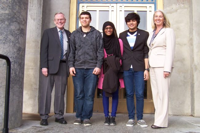 Exchange students from the Middle East Haytham Mohanna, Maha Abdulrazzaq, and Abdulla Husain pose with Sen. Dennis Egan and Rep. Cathy Munoz during a visit to the Capitol in January. (Photo courtesy of Alida Bus)