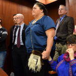 In the Senate gallery, an emotional Rep. Charisse Millett holds hands with Liz Medicine Crow while Senators debate the fate of the bill. The legislation, which passed moments later, makes 20 Alaska Native languages official state languages alongside English. (Photo by Skip Gray/Gavel Alaska)