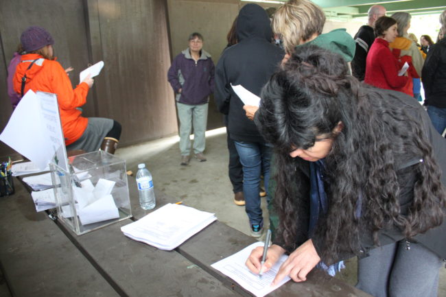 Members of the public write comments about the candidates during the superintendent finalist meet and greet at Savikko Park Sunday. The school board consider the comments during deliberations. (Photo by Lisa Phu/KTOO)