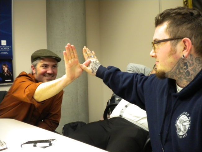 UAS assistant professor Sol Neely, left, demonstrates a special handshake with student Shawn Jessup. Neely advises the Flying University club, a campus support group for students transitioning from prison to college. (Photo by Kevin Reagan/ KTOO)