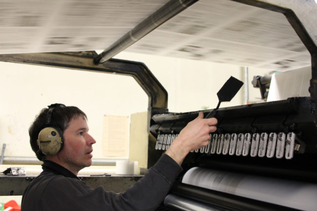 James Poulson makes sure the ink is evenly distributed on the press. 