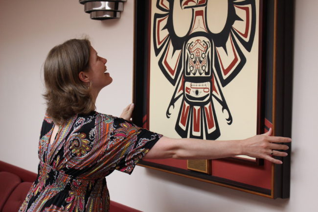 Pyper Powell straightens a picture at SEARHC's new location for behavoiral health services. (Photo by Elizabeth Jenkins/KTOO) 