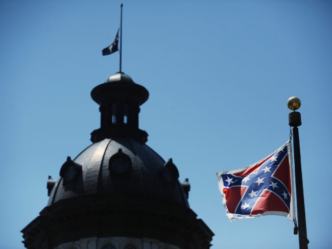 The Confederate flag flies near the South Carolina Statehouse, Friday, June 19, 2015, in Columbia, S.C. Tensions over the Confederate flag flying in the shadow of South Carolina's Capitol rose this week in the wake of the killings of nine people at a black church in Charleston, S.C. Rainier Ehrhardt/Associated Press