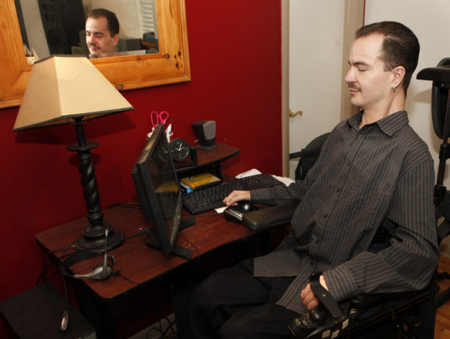 Brandon Coats works on his computer at his home in Denver in December 2012. (Photo by Ed Andrieski/AP)