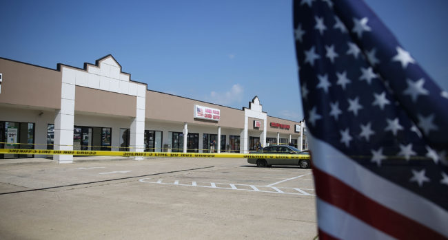 Members of the FBI Evidence Response Team investigate the shooting at the Armed Forces Career Center/National Guard Recruitment Office on July 17 in Chattanooga, Tenn. Since the shooting, armed civilians have begun trying to guard such centers. Joe Raedle/Getty Images