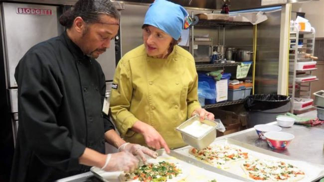 Trainee Dajaun Alexander preps pizzas with chef instructor Susan Logozzo in an industrial kitchen at Community Servings in Jamaica Plain, Massachusetts. Career training programs like this have been shown to vastly improve a person’s chances of staying clean and sober. (Photo by Amanda Marsden/Community Servings)