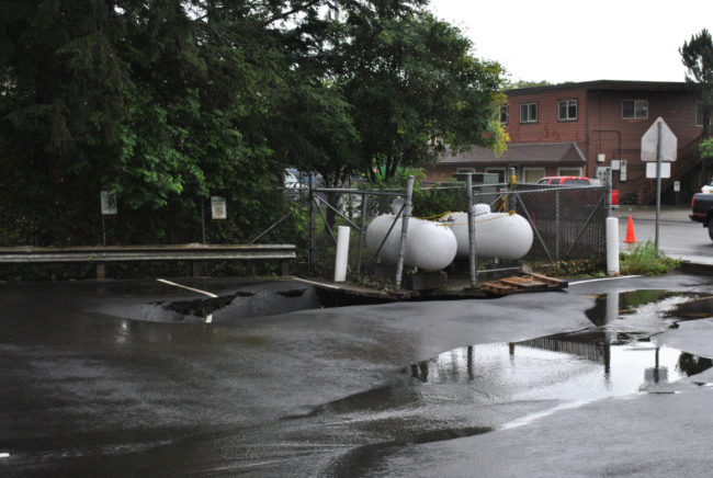 A sinkhole opened up beneath a pair of propane tanks on Halibut Point Road. (Photo by Rebecca LaGuire/KCAW)