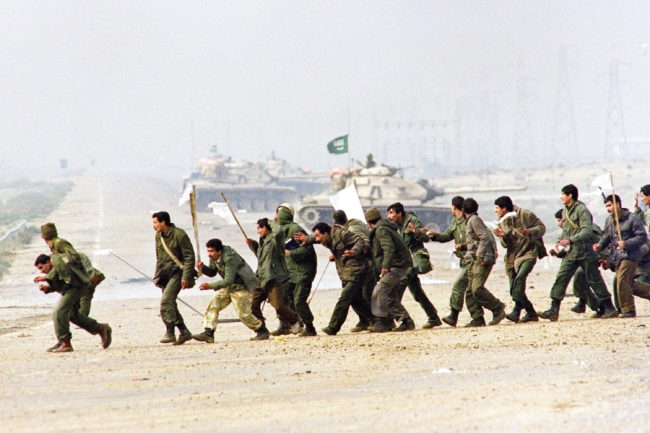 Iraqi soldiers cross a highway carrying white surrender flags on Feb. 25, 1991, in Kuwait City. The U.S.-led coalition overwhelmed the Iraqi forces and swiftly drove them out of Kuwait. Christophe Simon/AFP/Getty Images