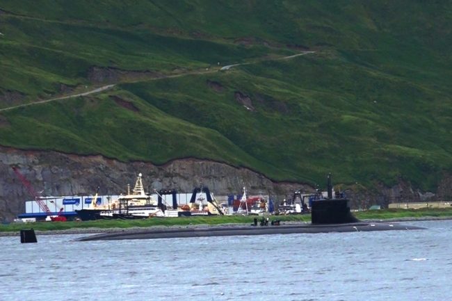 Crew members stand atop the USS Seawolf in Unalaska Bay, Alaska. (Photo by Pipa Escalante/KUCB)