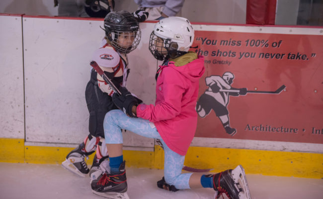 Kyla Bentz helps Violet Young get acquainted with the ice during JDIA’s Learn to Play afternoon at Treadwell Ice Arena. (Photo by Steve Quinn)