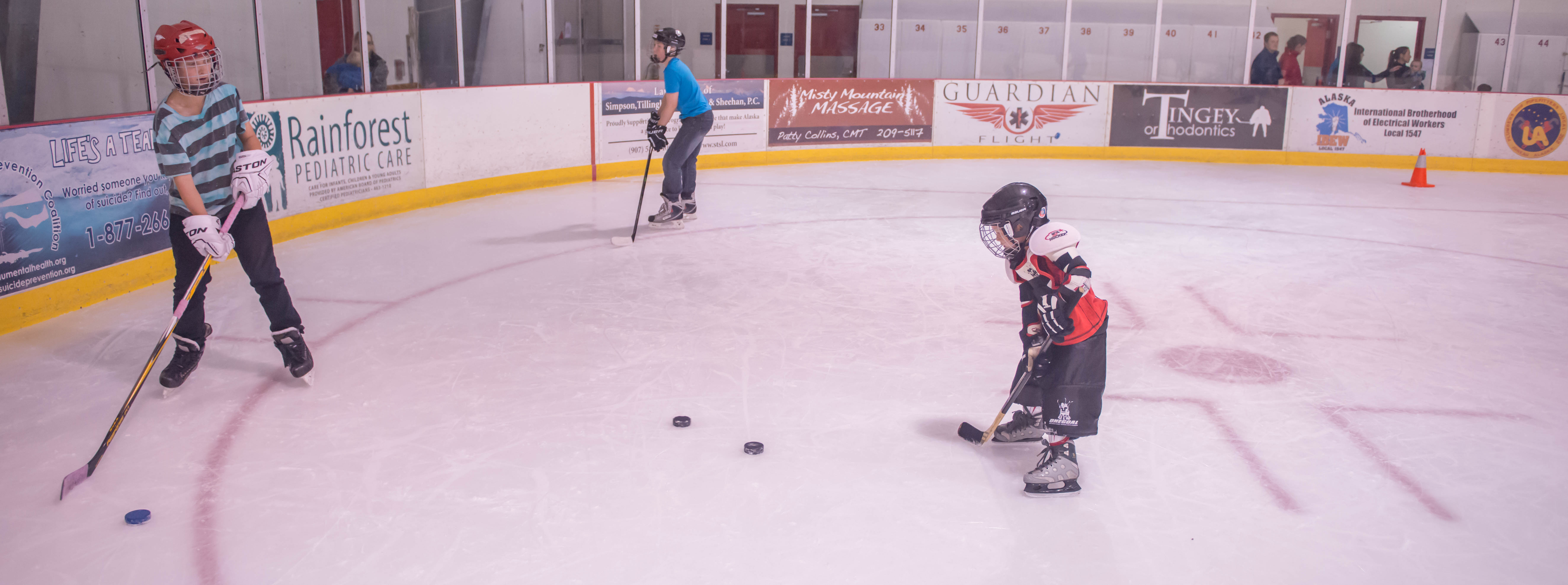 Jack York works with Braedon Pearson during JDIA’s Learn to Play afternoon at Treadwell Ice Arena. (Photo by Steve Quinn)