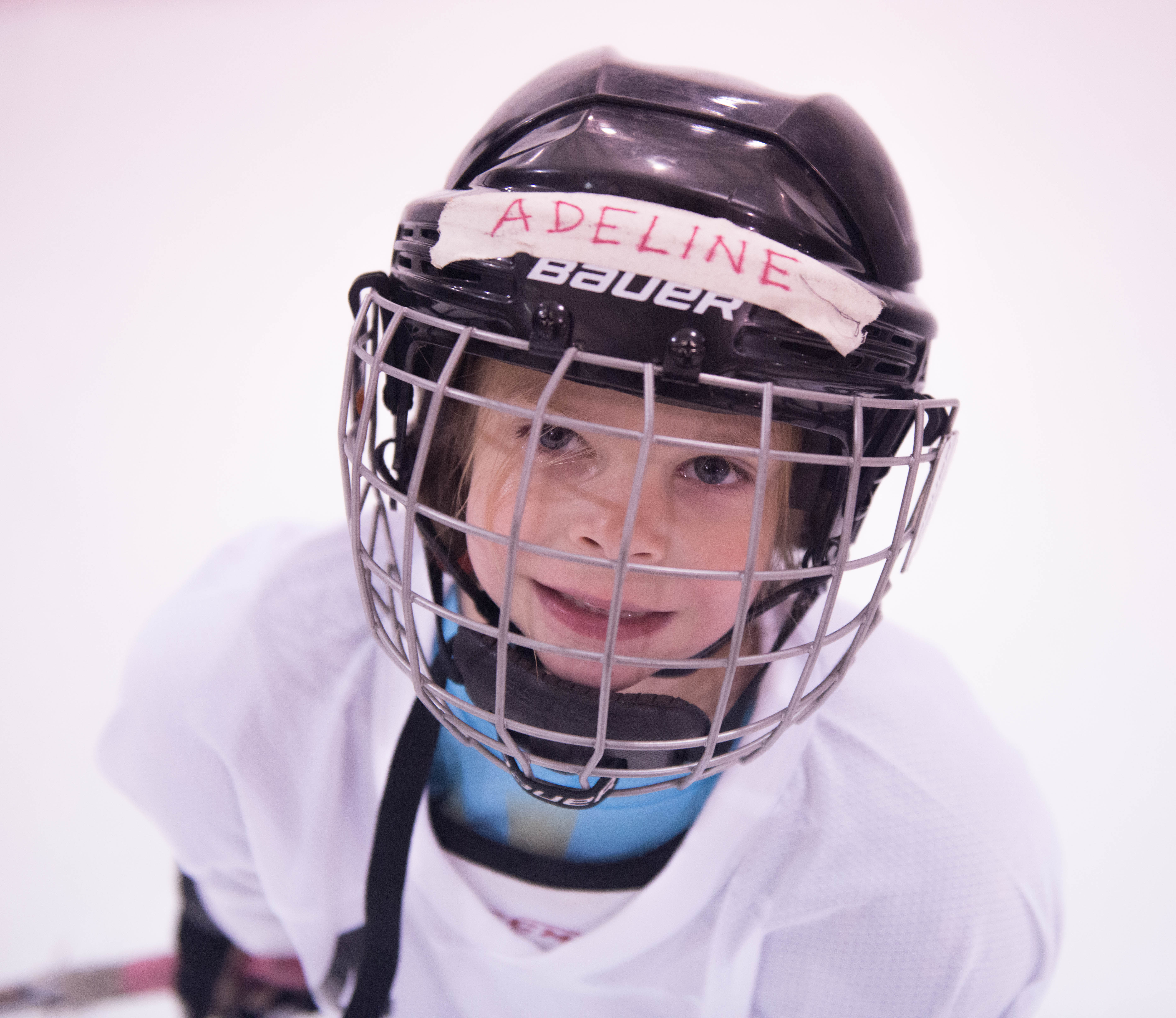 Adeline Janson flashes a quick smile through her hockey cage while skates around Treadwell Ice Arena at JDIA’s Learn to Play afternoon. (Photo by Steve Quinn)
