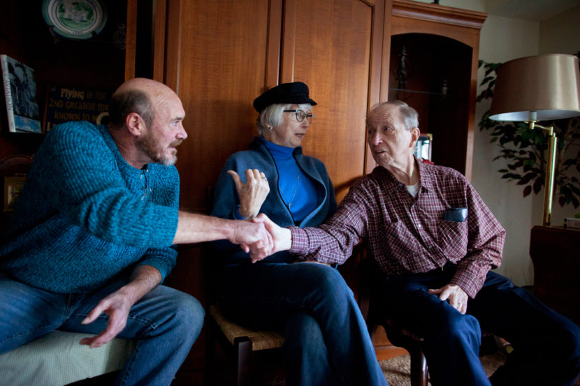 Donnie Lehman (left), Chris Cable and Cyril Syoboda introduce each other before the Make Room concert at Tom Wall's apartment. Lehman used to be homeless, living on the streets, before Wall brought him in as a roommate. Brandon Chew/NPR