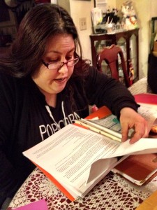 Angela LaRose scours documents related to the death of her sister. (Photo by Liz Ruskin/APRN)