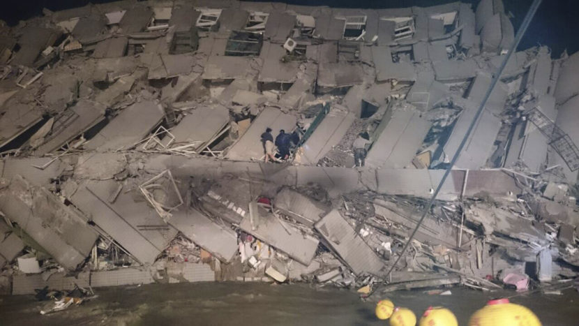 Rescuers are seen entering an office building that collapsed on its side from an early morning earthquake in Tainan, southern Taiwan, Saturday. The quake's magnitude was 6.4, according to the U.S. Geological Survey. (AP)