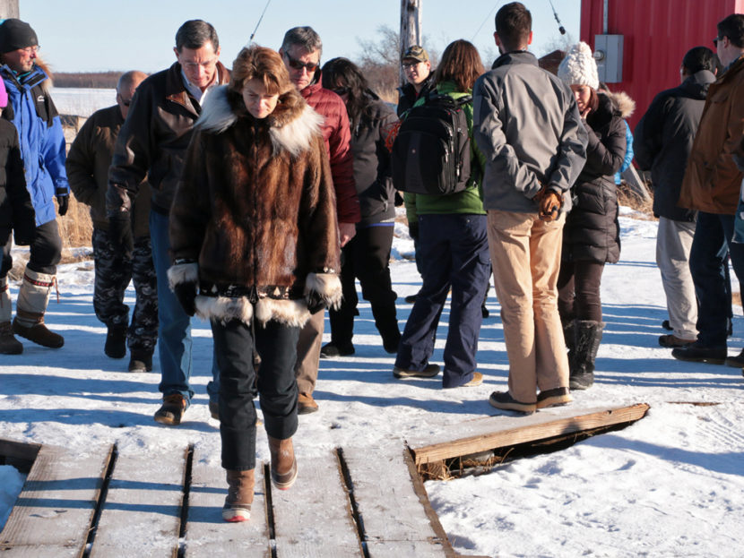 US Sen. Lisa Murkowski walking through Oscarville, followed by U.S. Sen. John Barrasso and AVCP Executive Vice President Mike Hoffman. (Photo by Dean Swope/KYUK)