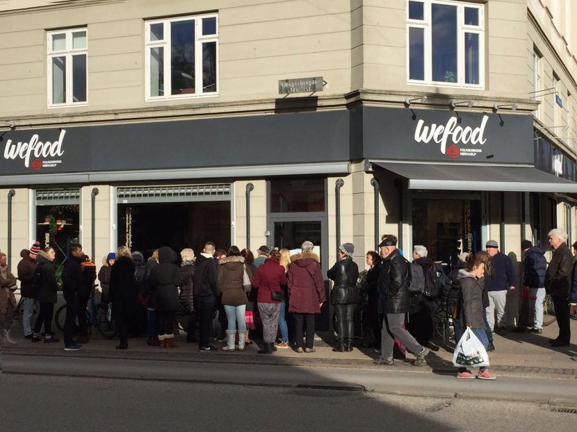 A crowd waits on the sidewalk for the WeFood grocery store in Copenhagen to open. It's not the first grocer in Europe to sell surplus food. But unlike so-called "social supermarkets" – stores which serve almost exclusively low-income people — WeFood's offerings are very intentionally aimed at the general public. DanChurchAid