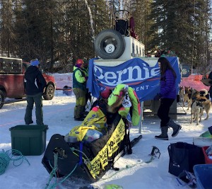 Monica Zappa displays a Bernie Sanders banner at the Iditarod restart in Willow. (Photo by Zach Hughes/KSKA)