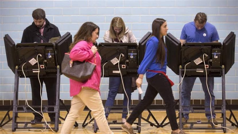 A poll worker leads a voter to an electronic voting machine in Columbus, Ohio. Many computerized voting machines are reaching the end of their life span and governments must figure out what to replace them with and how to pay for it. AP