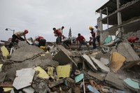 Volunteers search for survivors in the debris of buildings destroyed by an earthquake in Pedernales, Ecuador on Sunday. Dolores Ochoa/AP