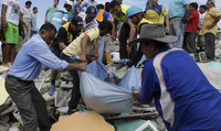 Volunteers rescue a body from a destroyed building in Pedernales on Sunday. Dolores Ochoa/AP