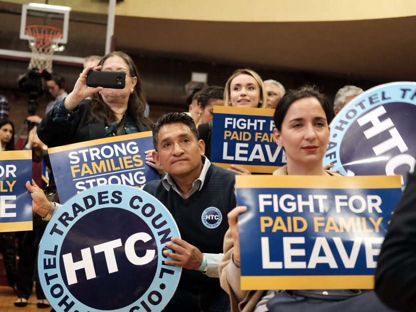 Supporters watch as New York Gov. Andrew Cuomo speaks to promote his paid family leave initiative at a rally in Manhattan on March 10. Spencer Platt/Getty Images