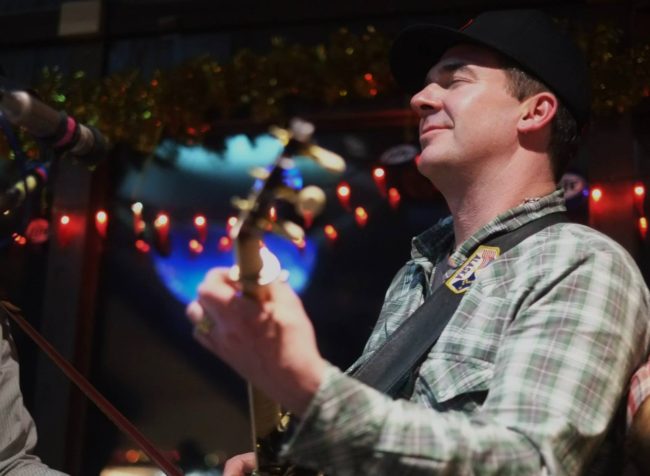 A photo of Jeremy Kane of the Great Alaska Bluegrass Band performing at Squires. (Photo By Annie Bartholomew/KTOO)