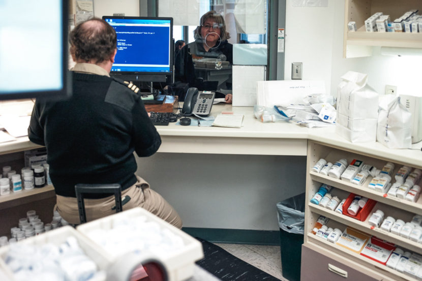 Hoff picks up prescriptions at the Indian Health Service clinic in Wagner. The pharmacy staff member is part of the U.S. Public Health Service Commissioned Corps. Misha Friedman for KHN and NPR