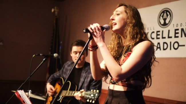 A picture ofTaylor Vidic singing into the microphone at the KXLL NYE Block Party at the Hangar on the Wharf. (Photo by Annie Bartholomew/KTOO