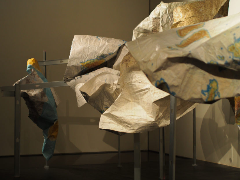 “Subsistence,” a sculpture by Marek Ranis from old military maps suspended on metal fish racks, part of the Anchorage Museum’s “The View From Up Here” exhibit. (Photo Zachariah Hughes/Alaska Public Media)