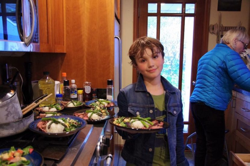 Denali Schijvens, serving a recent dinner for 12. Nancy Hemenway, right, says he planned and executed the meal while she served as sous chef. (Photo courtesy of Sander Schijvens)