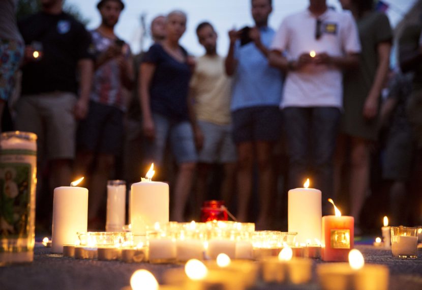 Mourners gather around candles lit during a vigil after a fatal shooting at the Pulse Orlando nightclub on Sunday. David Goldman/AP