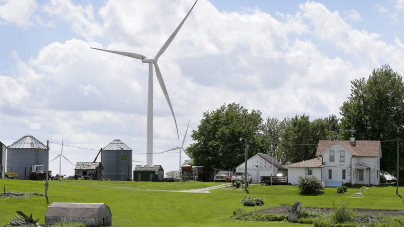 A wind turbine stands over a farmhouse in Adair, Iowa. Charlie Neibergall/AP