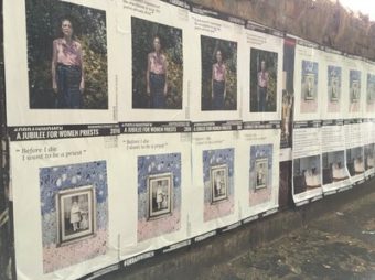 Posters touting the Women Priests Project along a wall.