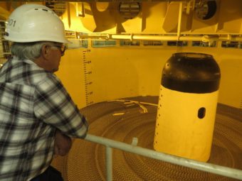 Reggie Joule looks over tanks of coiled fiber optic cable in the Ile de Brehat. (Photo by Laura Kraegel/KUCB)