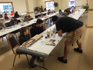 Ron Fairbanks teaching kids how to paint formline. (Aaron Bolton, KSTK)
