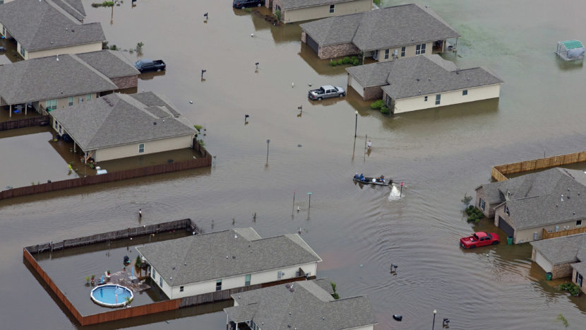 In this aerial photo a boat motors between flooded homes on Saturday after heavy rains in the region in Hammond, La. Max Becherer/AP
