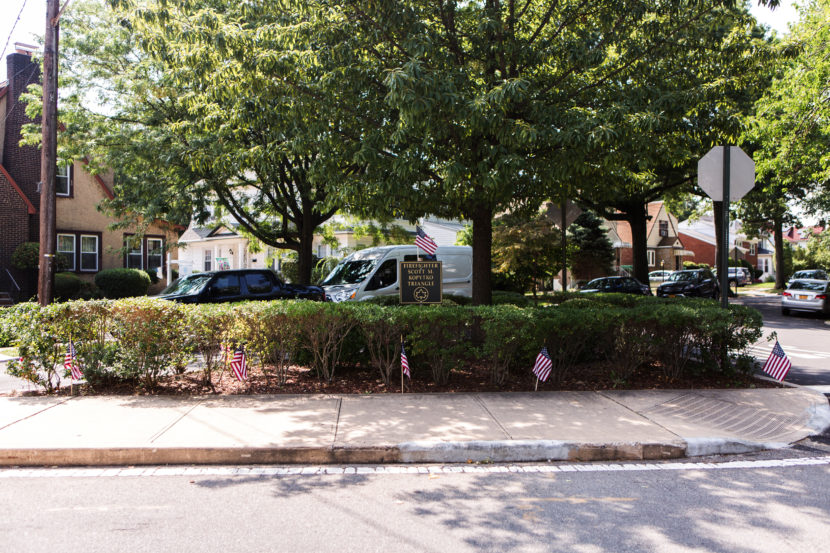 Scott Kopytko's parents plant flags and flowers at the Firefighter Scott M. Kopytko Triangle in Flushing, Queens. Alex Welsh for NPR