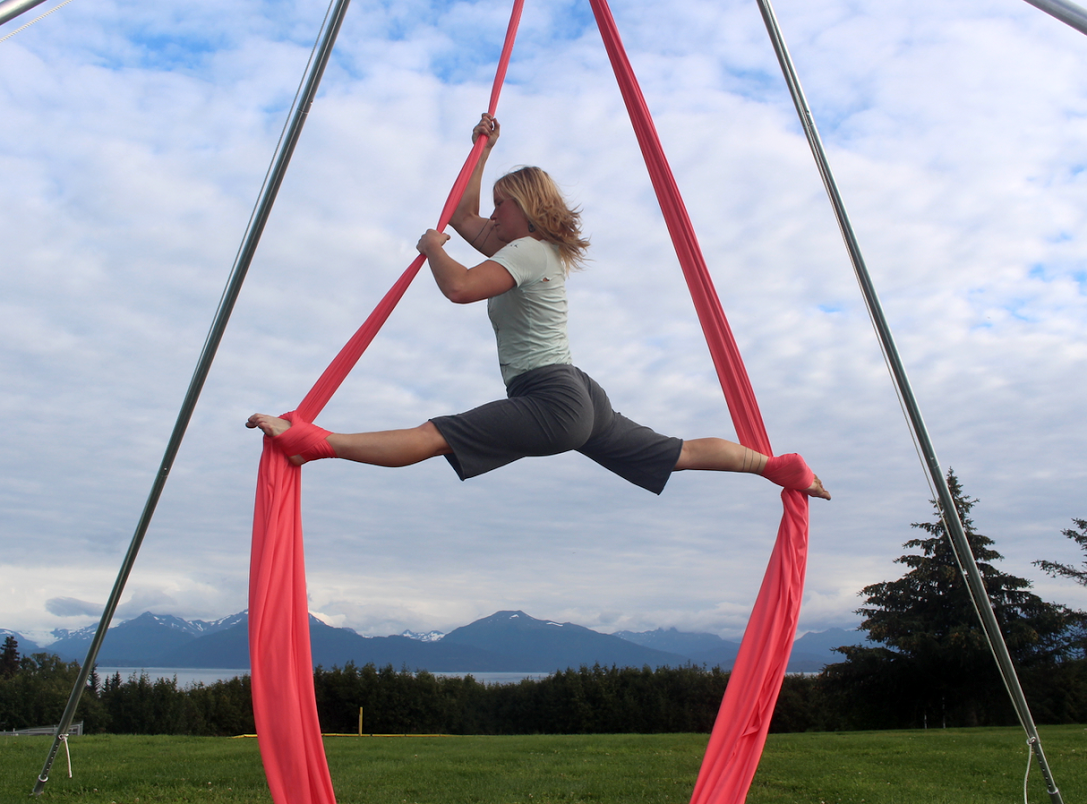 Instructor Bridget Doran practicing aerial silk art above Kachemak Bay. (Photo courtesy of Kammi Matson)