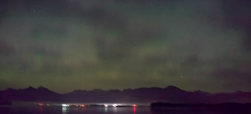 Greens and hints of red fill the sky over the Mendenhall Valley at midnight, Sept. 29, 2016.