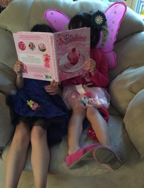 Rusty and Lola read a cupcake cookbook together. (Photo by Anne Hillman/Alaska Public Media.)