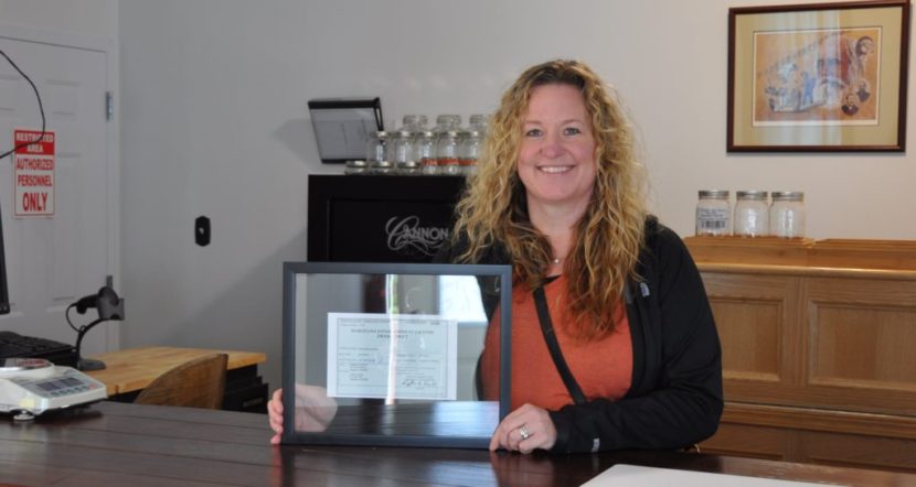 Tara Bass with in the Remedy Shoppe with her license to open.