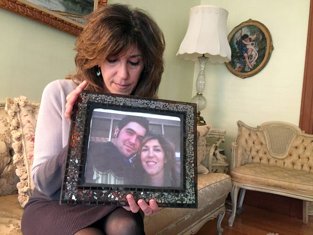 Debbie Deagle holds a photo of her son Stephen and herself. (Photo by Martha Bebinger/WBUR)