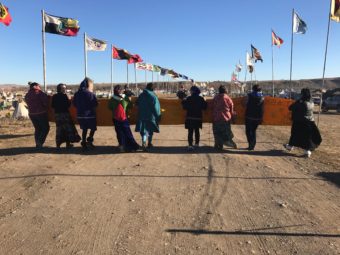 The group carried the flag and banner into the camp and sang Athabascan songs. (Photo by Amanda Frank)