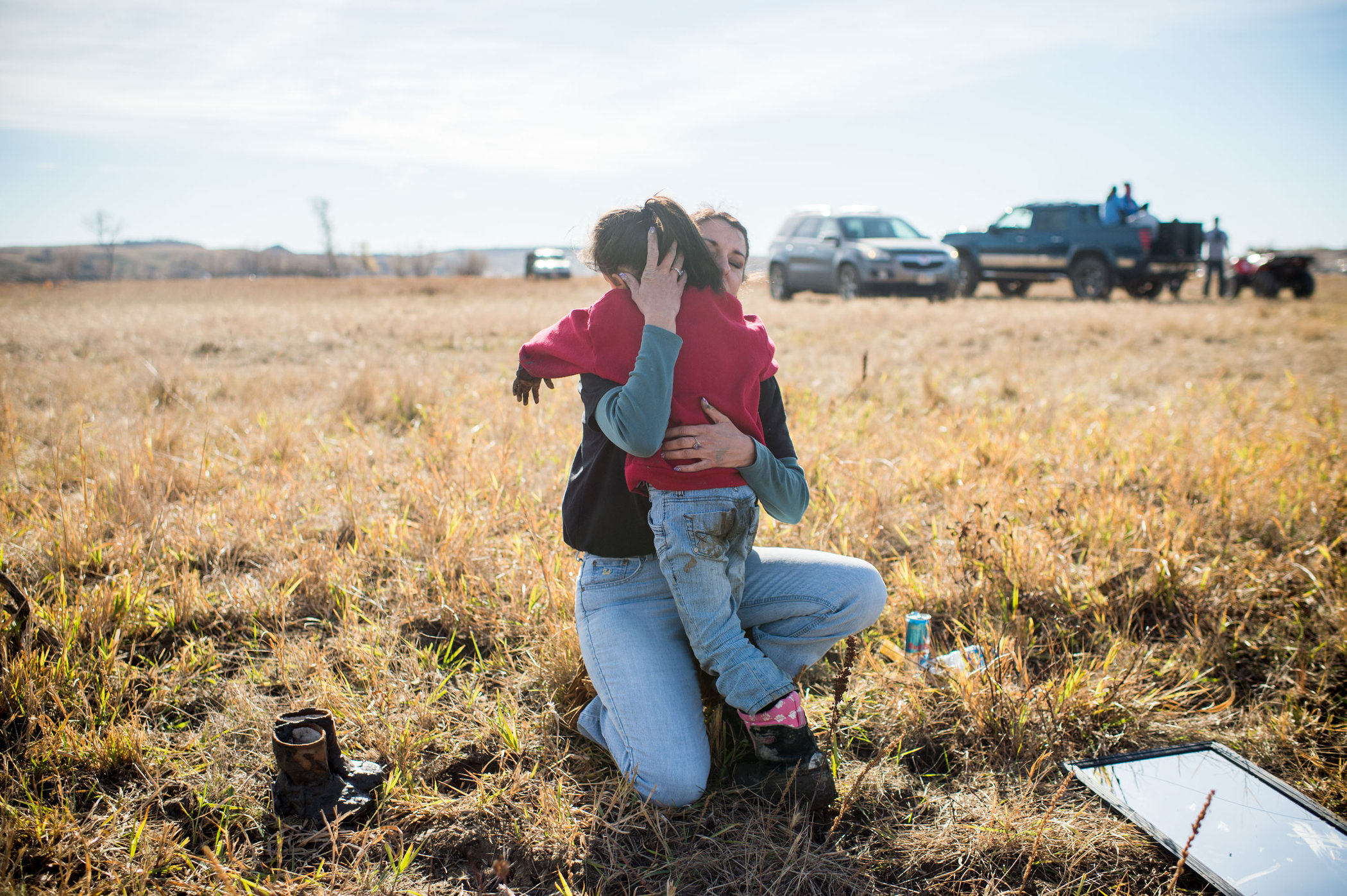 Samantha Putchit Echumblee, 5, of Greenville, Tenn., hugs her mother, Audrie Ellen, during protests at the river. (Photo by Emily Kask for NPR)