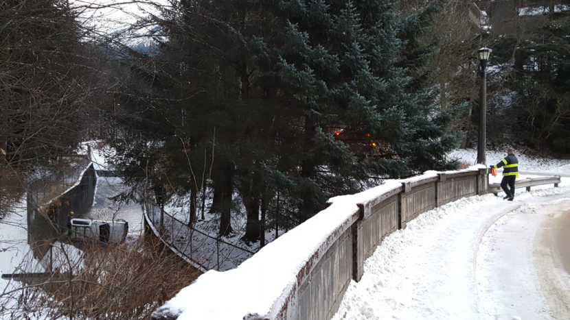 Authorities inspect the area around a vehicle that was found on its side in Gold Creek near Cope Park. (Photo by Tripp J Crouse/KTOO)