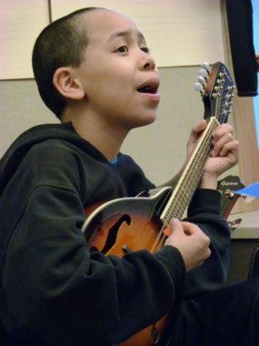 Gastineau Elementary School student Sophia Lundeman sings and plays guitar during a music class led by Patrick Murphy. (Photo by Ed Schoenfeld/ CoastAlaska News)