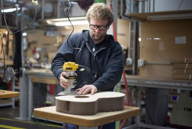 Worker routs the top of an acoustic guitar. Photo credit: RA Beattie/Musicians for Forests