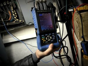 Engineer Mike Gaffney uses a power quality analyzer to measure the energy use of the vessel’s lighting. (Emily Russell/KCAW).